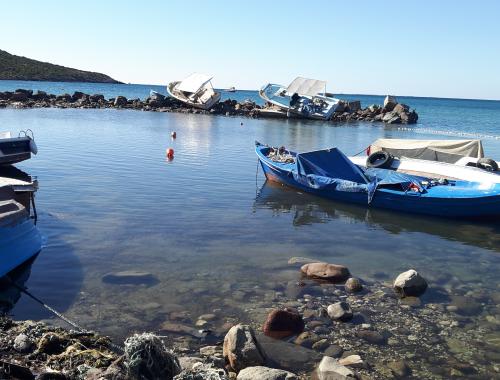 small bay with calm water and slightly destructed boats